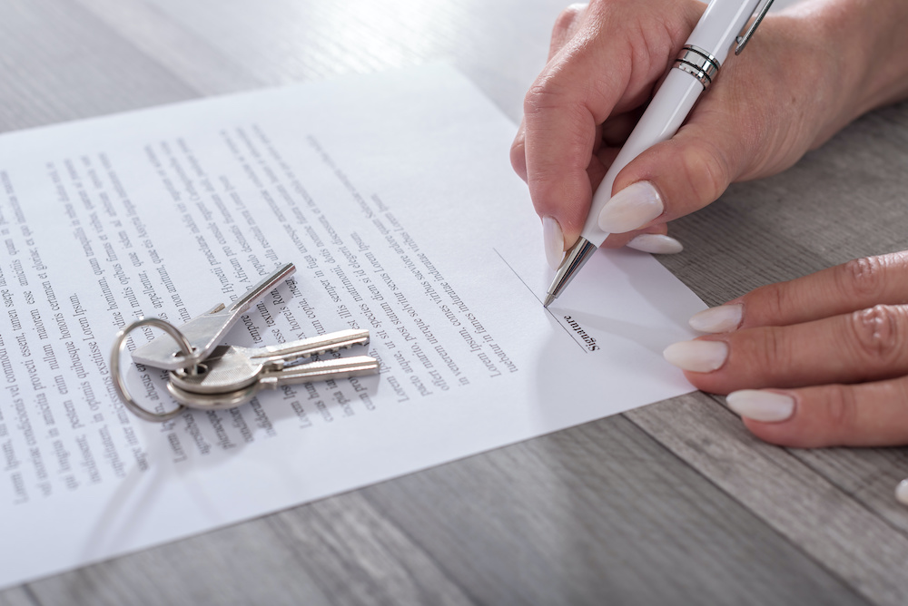 Female customer signing a commercial real estate contract with a real estate expert witness