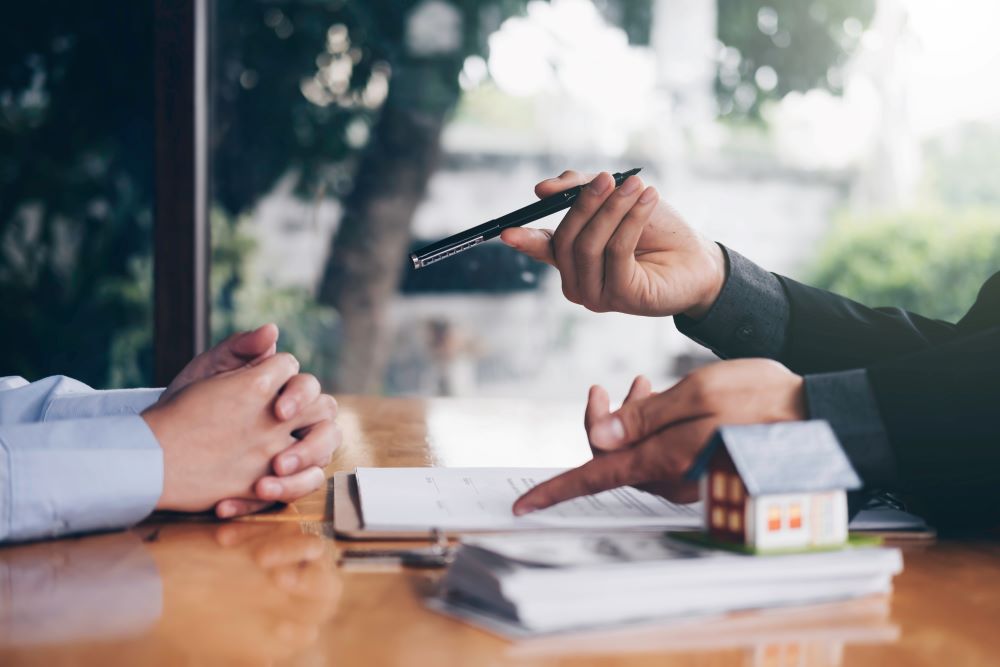 A seller refusing to sign a document to sell his home.
